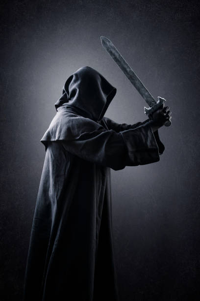 istock Warrior with hooded cape and medieval sword over dark misty background 1369572425