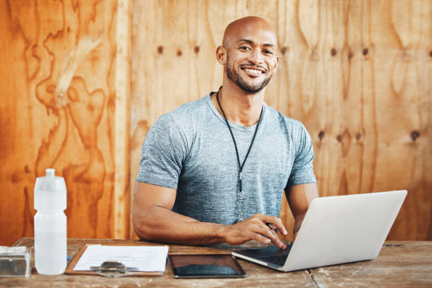 istock Portrait of a muscular young man using a laptop while working in a gym 1369575084