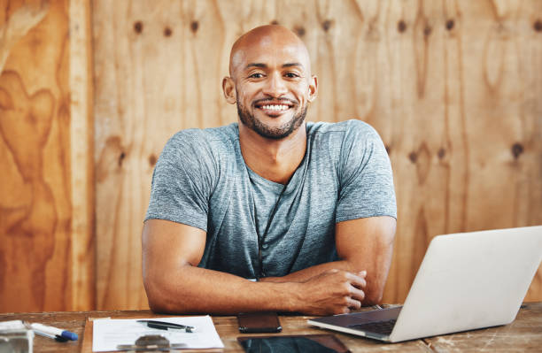 istock Portrait of a muscular young man using a laptop while working in a gym 1369575085