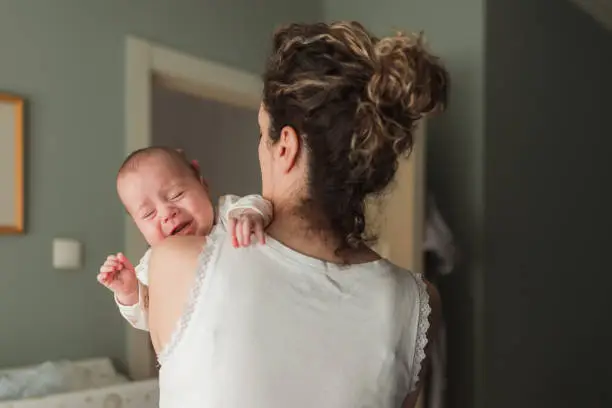 Newborn baby crying when being held in mother's arms