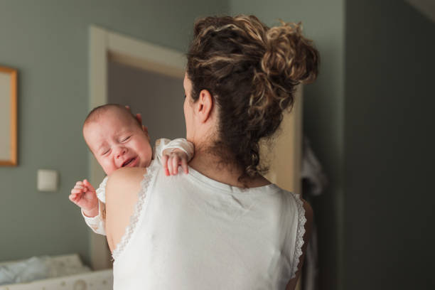 mulher tomando carro de um bebê recém-nascido chorando - mother new baby nursery - fotografias e filmes do acervo