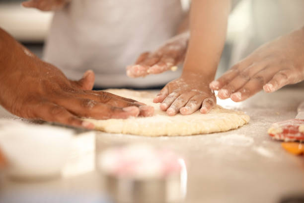 istock Cropped shot of an unrecognizable girl using a cookie cutter while making cookies at home 1369576582
