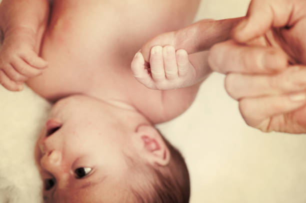 彼の人生の最初の週に生まれたばかりの赤ちゃん - hands and feet flash ストックフォトと画像