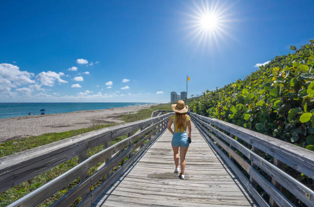 istock Woman walking on boardwalk on beautiful Florida beach. 1369577364