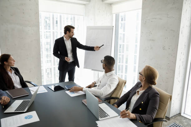 istock Corporate mentor, coach teaching interns at modern office meeting workspace 1369578627