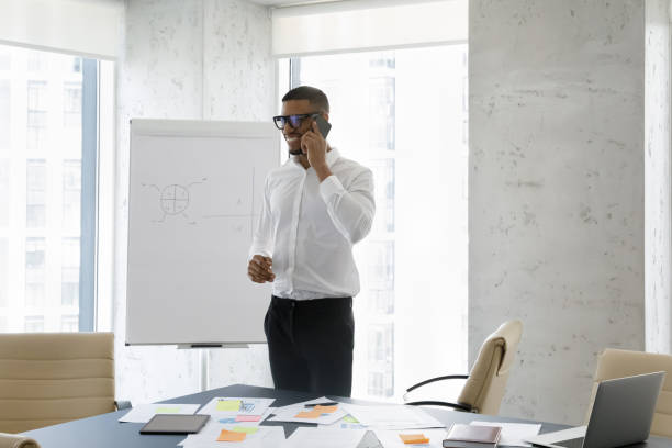 istock Happy friendly successful African businessman talking on mobile phone 1369578643