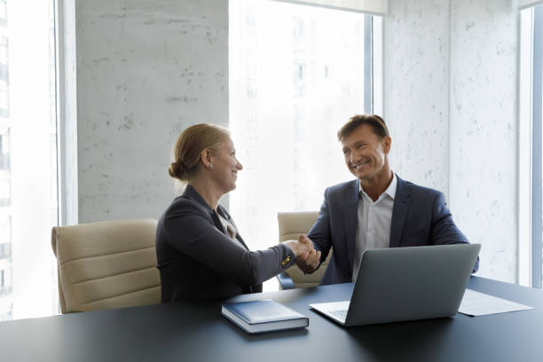 istock Happy confident business partners in formalwear shaking hands after negotiation 1369578674