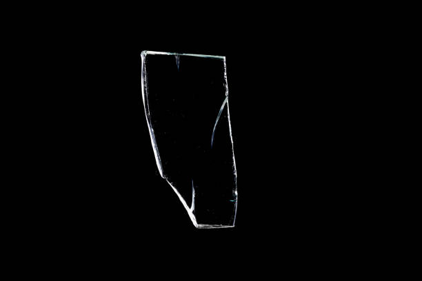 sharp shard of glass insulated against a black background. High quality photo