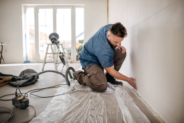 Drywall Sander Worker kneels and sands the wall house painter stock pictures, royalty-free photos & images