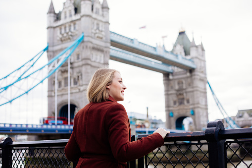 Young woman looking at Tower Bridge in London