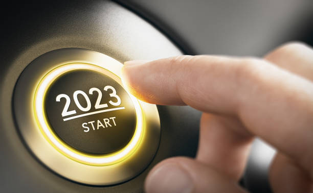 Year 2023 Start, Two Thousand and Twenty Three Concept. Finger about to press a car ignition button with the text 2023 start. Year two thousand and twenty three concept. Composite image between a hand photography and a 3D background. pre press stock pictures, royalty-free photos & images