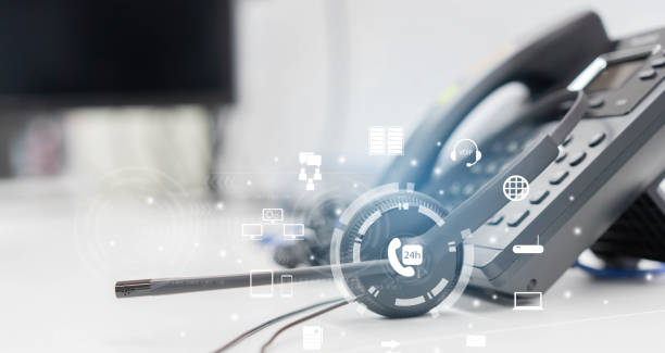 close up headset of call center and VOIP communication with futuristic virtual icon telecommunication technology on office table in monitoring room for network operation job concept stock photo