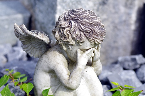 Weeping angel made of stone at the grave