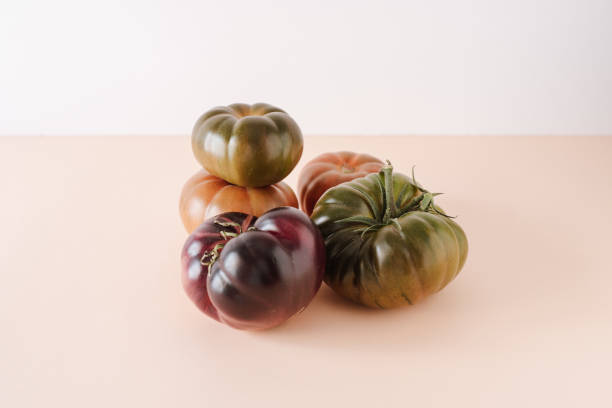 istock Tomatoes of different varieties and different colors. On a warm colored background, isolated. Close up. Still life. 1369584455