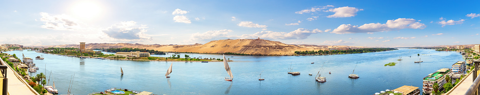 Full panorama of the Nile and sailboats by the banks of Aswan, Egypt.