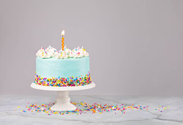 istock Blue Birthday Cake with sprinkles and Birthday Candle 1369588567