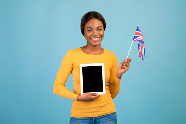 istock Study English Online. Black Female Holding British Flag And Blank Digital Tablet 1369588876