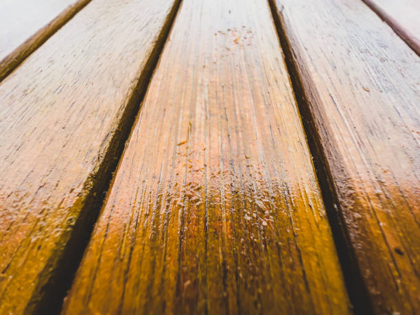istock Wet light wood of a garden table. 1369590494