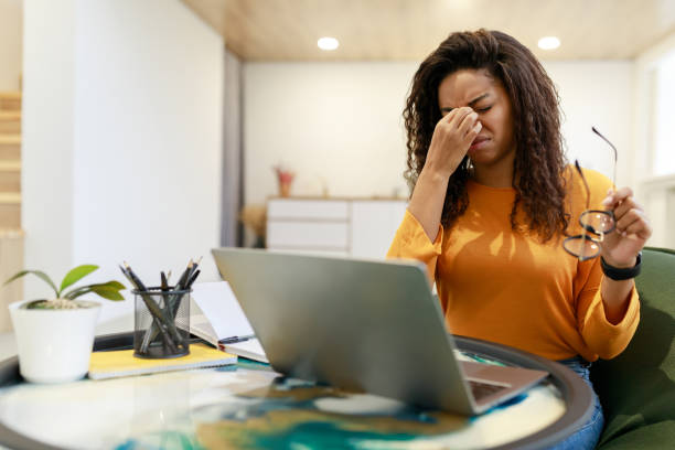 istock Tired black female worker sitting at desk with pc 1369593152