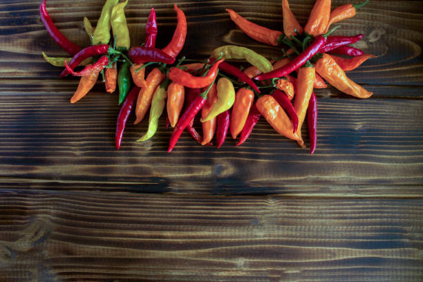 istock Colored pepper on on the brown wooden background. Top view. Copy space. 1369596114