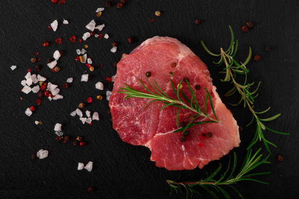 istock Fresh steak with herbs and spices at black background. 1369596343