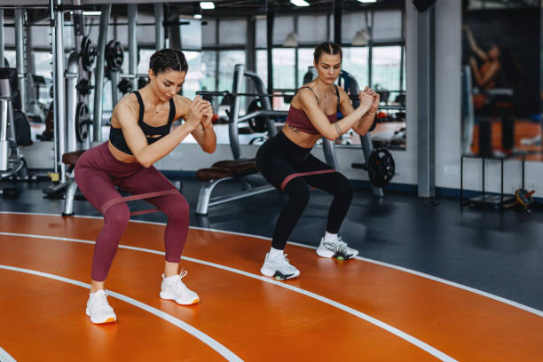 istock Two young, smiling, happy, women exercise, stretching stepper gym. 1369597473