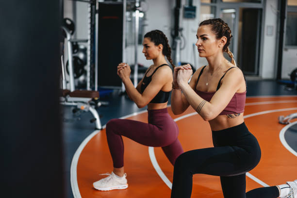 istock Young Women Doing Stretching Exercises In Gym 1369597592