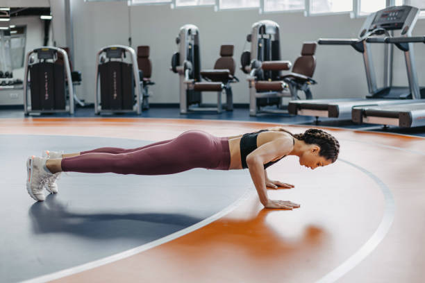 istock Young woman doing push-ups at the gym. 1369597663