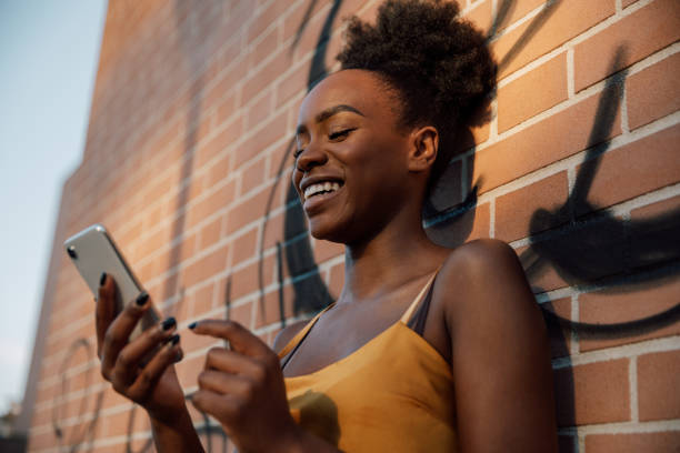istock Young woman texting on mobile outdoor 1369597695