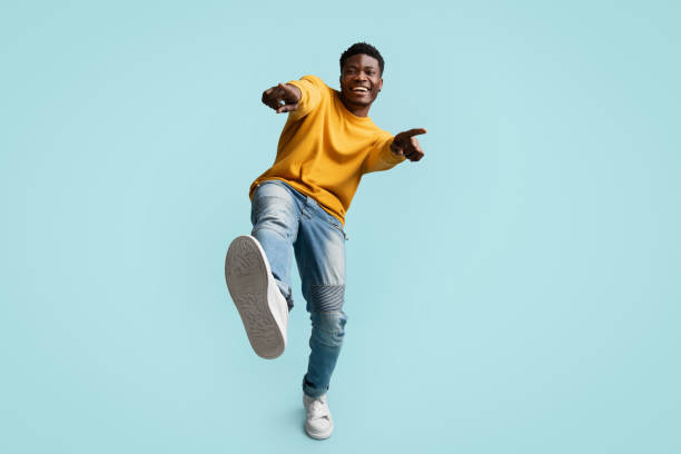 istock Carefree handsome black guy posing on blue, laughing and gesturing 1369597773