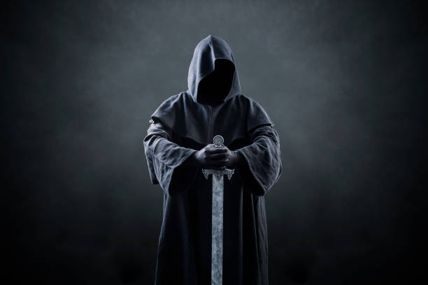 istock Warrior with hooded cape and medieval sword over dark misty background 1369601707