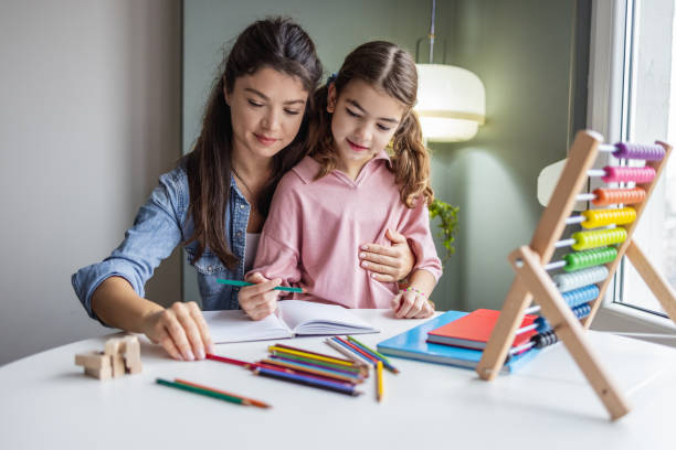 istock Mother helps her daughter to study at home 1369601959