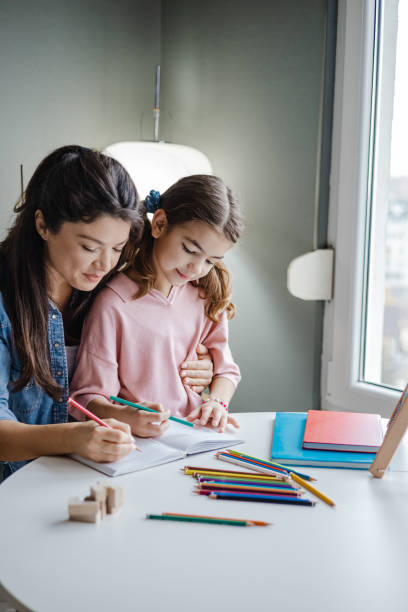istock Mother helps her daughter to study at home 1369601960