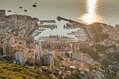 Aerial view of the Principality of Monaco at sunrise, Monte-Carlo, old town, view point in La Turbie at morning, port Hercule, Prince Palace, Mountains, Megayachts, a lot of boats, sun reflection