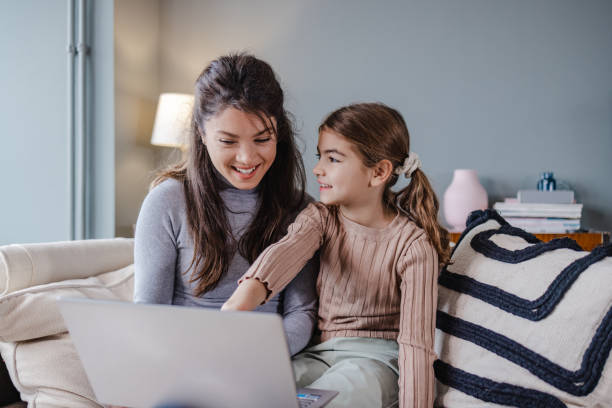istock Mother and daughter using laptop at home and smiling 1369602706