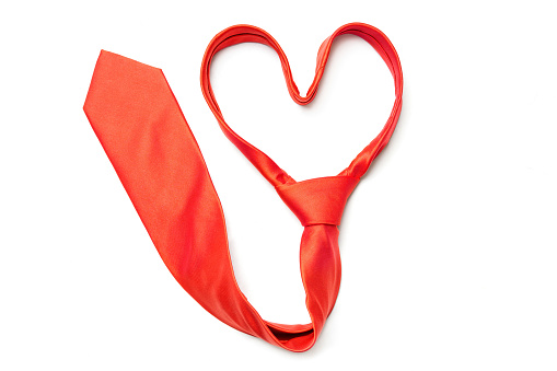 Heart shape folded red necktie isolated on a neutral background. Creative romantic occasion outfit concept.