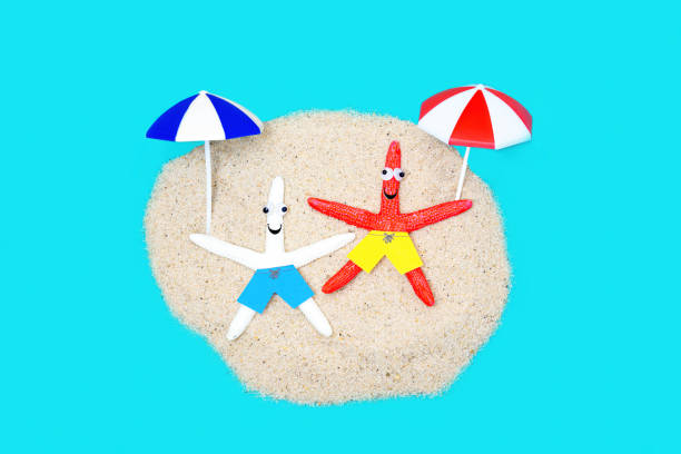 istock Two starfish characters relaxing on the sandy beach 1369603426