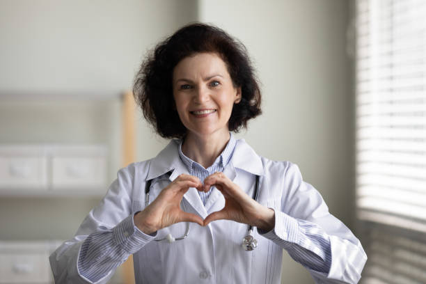 istock Happy beautiful middle aged doctor making heart gesture. 1369604062