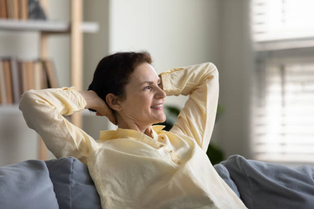 istock Happy old woman resting on sofa at home. 1369604089