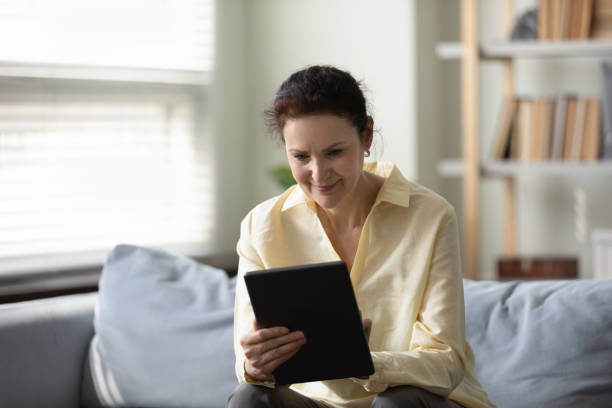 istock Happy old woman using digital tablet at home. 1369604090