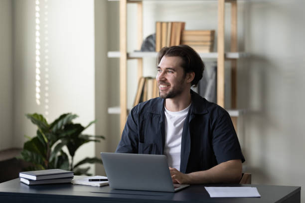 istock Happy handsome young businessman looking in distance. 1369604108