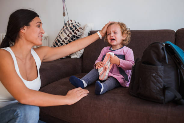 istock Young mother cuddling her crying daughter and smiling 1369605985