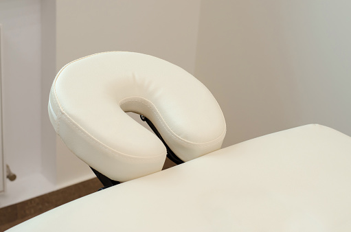 Beige headrest on a massage table close-up.