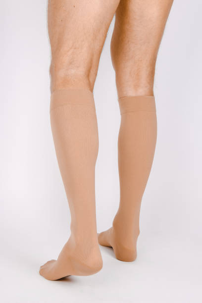istock Medical Compression Stockings for varicose veins and venouse therapy. Compression Hosiery. Sock for sports isolated on white background. Beige color socks mock up for advertising, branding, design 1369610143