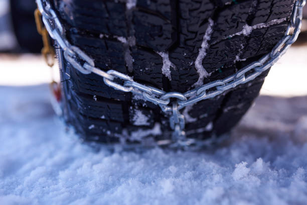 chaîne à neige sur une roue dans la neige profonde en hiver - close up truck pick up truck gear photos et images de collection