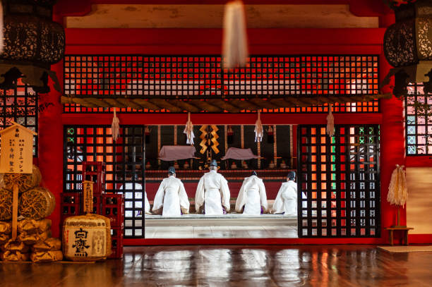 Hiroshima, Japan. December 31, 2019. Five buddhist monks praying in the Itsukushima Shrine near Hiroshima, Japan.