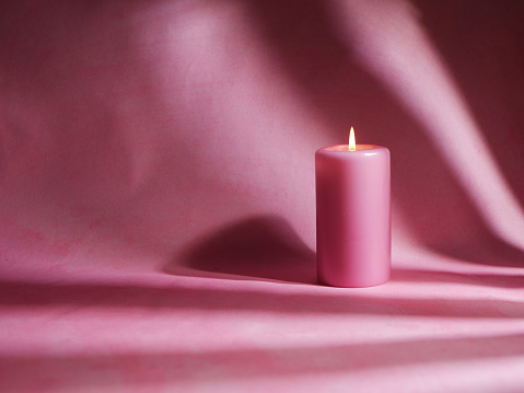 Romantic pink candle on pink background medium shot selective focus