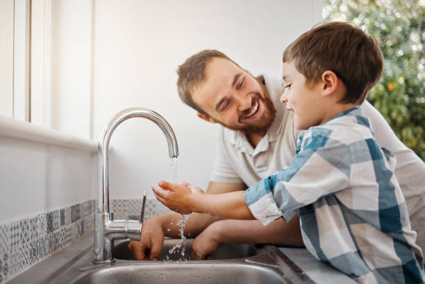 自宅で手を洗う男と幼い息子のショット - two parent family indoors home interior domestic kitchen ストックフォトと画像