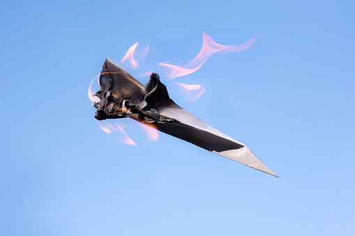 burning paper plane in the sky