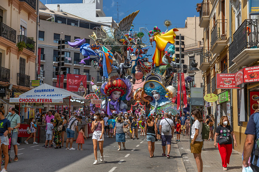 General view of a Falla during Las Fallas Festival on September 3, 2021 in Valencia, Spain. The Fallas is Valencias most international festival, which runs from March 15 until March 19, but because the COVID, in 2021 was celebrated in september. It celebrates the arrival of spring with fireworks, fiestas and bonfires made by large puppets named Ninots. During the months preceding this unique festivity, a lot of hard work and dedication is put into preparing the monumental and ephemeral cardboard statues that will be devoured by the flames. The festival has been designated as a UNESCO Intangible Cultural Heritage of Humanity since 2017. People visit and look the falla.
